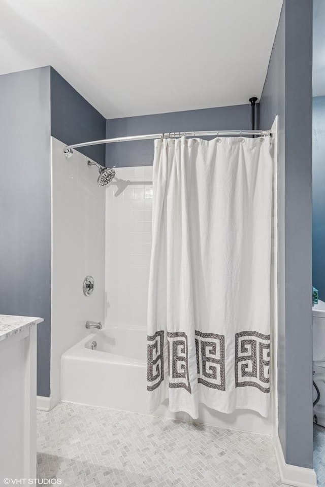 bathroom with shower / tub combo with curtain and baseboards