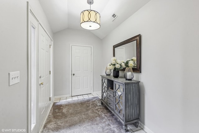 doorway to outside featuring vaulted ceiling, tile patterned flooring, baseboards, and carpet