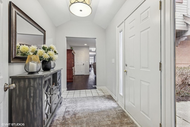 entryway with vaulted ceiling, tile patterned floors, carpet flooring, and baseboards