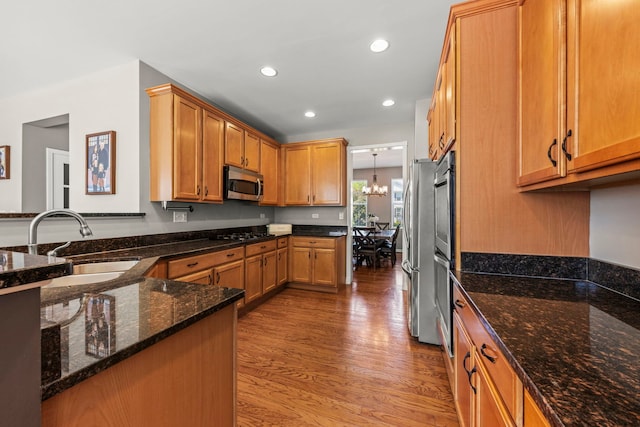 401 Manchester Rd, Oswego, IL 60543 - kitchen with stainless steel appliances, a sink, wood finished floors, dark stone countertops, and recessed lighting