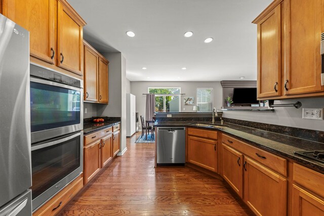 401 Manchester Rd, Oswego, IL 60543 - kitchen featuring stainless steel appliances, a sink, dark wood-type flooring, brown cabinetry, and recessed lighting