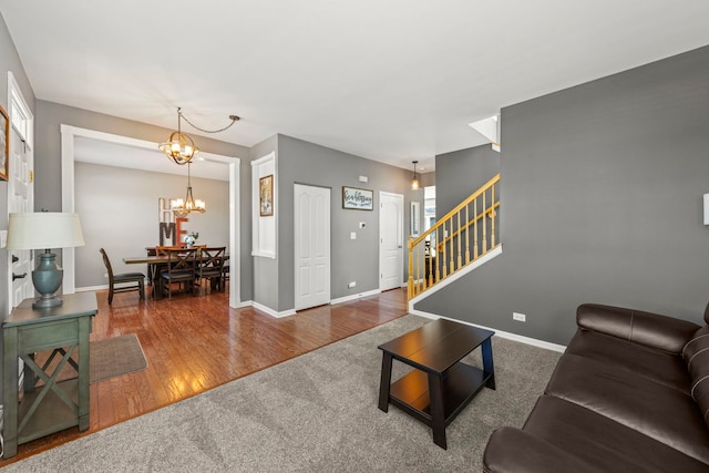 401 Manchester Rd, Oswego, IL 60543 - living room featuring stairway, a chandelier, baseboards, wood finished floors, and carpet flooring