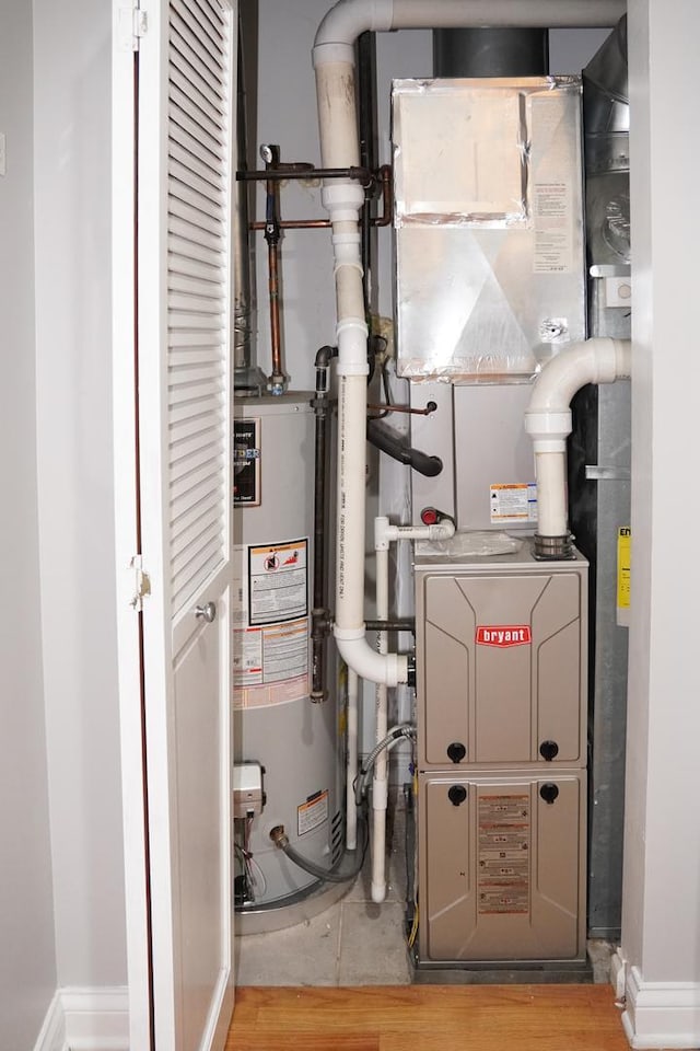 utility room featuring gas water heater and heating unit