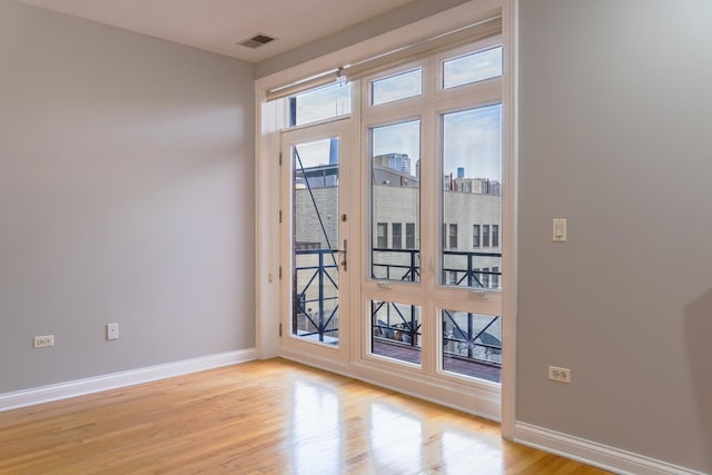 doorway featuring light wood-style flooring and baseboards