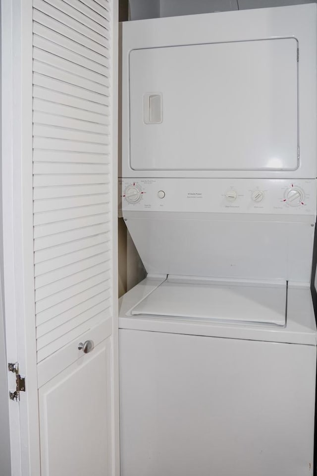 washroom featuring stacked washer and clothes dryer