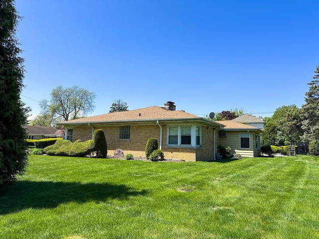 6600 N Kenton Ave, Lincolnwood, IL 60712 - rear view of house featuring brick siding, a lawn, and a chimney