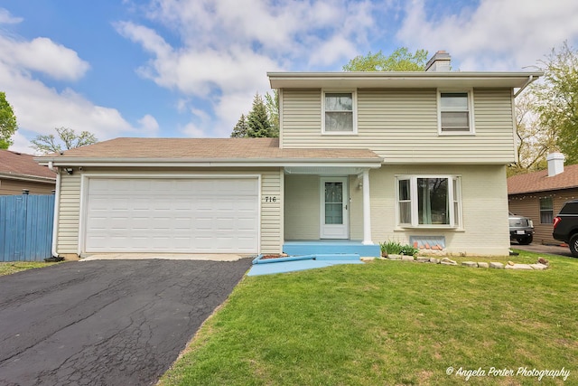 716 Lagoon Ter, Round Lake Beach, IL 60073 - view of front of home with asphalt driveway, a chimney, an attached garage, and brick siding