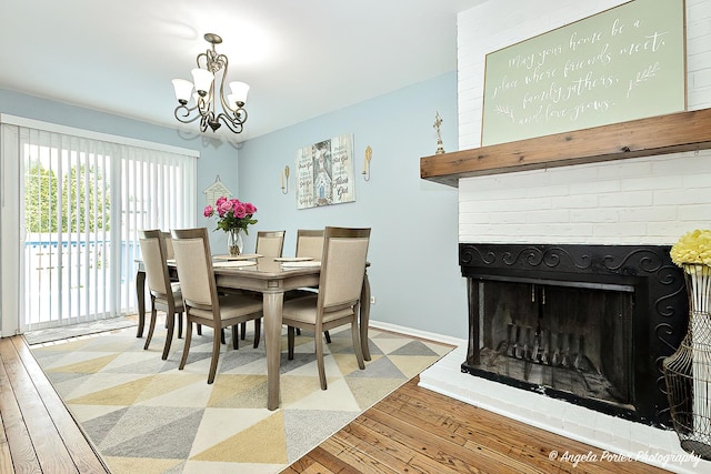 716 Lagoon Ter, Round Lake Beach, IL 60073 - dining room with a chandelier, hardwood / wood-style flooring, baseboards, and a fireplace
