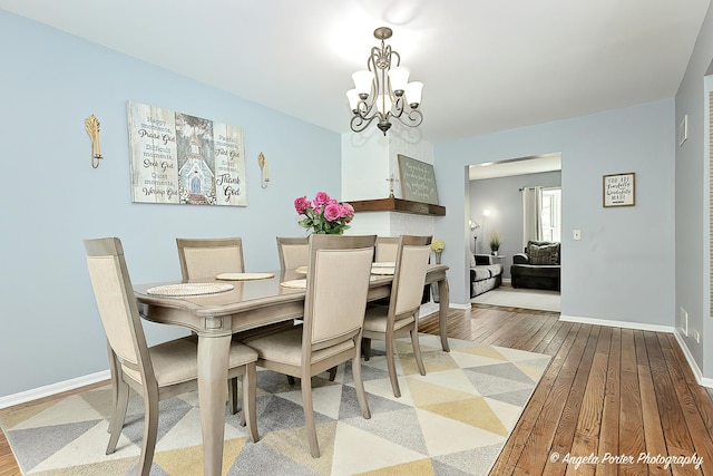 716 Lagoon Ter, Round Lake Beach, IL 60073 - dining room featuring a chandelier, hardwood / wood-style floors, and baseboards