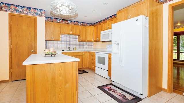 kitchen featuring white appliances, light tile patterned floors, light countertops, tasteful backsplash, and a chandelier