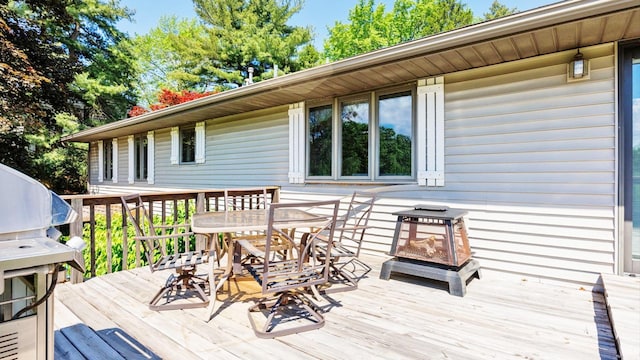 deck featuring outdoor dining space and a grill
