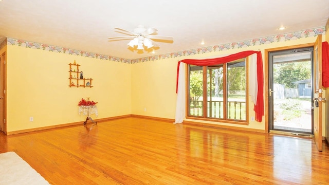 unfurnished room with light wood-style flooring, a ceiling fan, and baseboards