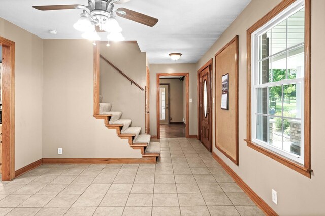 19423 Lakeside Ln, Bloomington, IL 61705 - foyer entrance featuring ceiling fan, stairs, baseboards, and light tile patterned floors