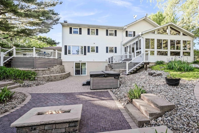 19423 Lakeside Ln, Bloomington, IL 61705 - back of property with a hot tub, a patio area, stairs, a fire pit, and a sunroom