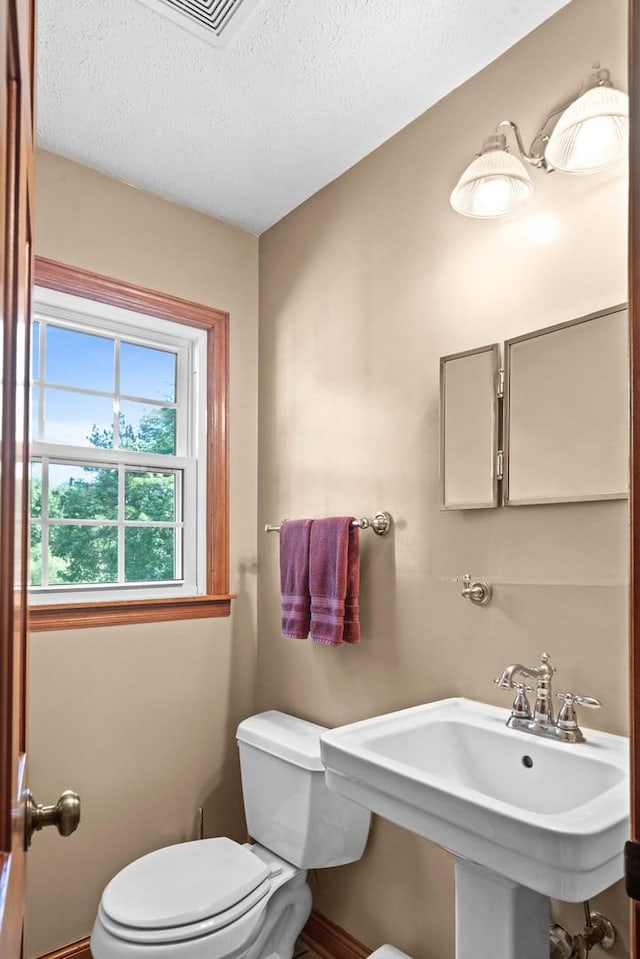 19423 Lakeside Ln, Bloomington, IL 61705 - half bathroom with toilet, a sink, a textured ceiling, and baseboards