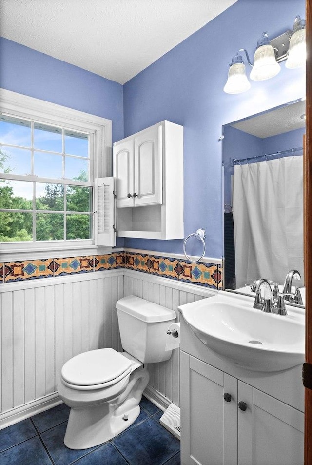 19423 Lakeside Ln, Bloomington, IL 61705 - bathroom featuring a wainscoted wall, toilet, tile patterned flooring, and vanity