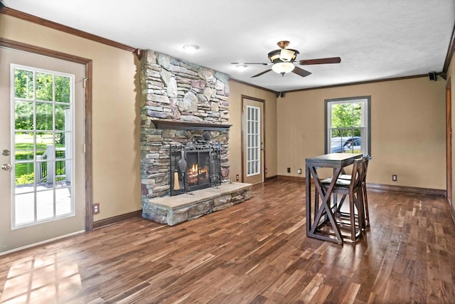 19423 Lakeside Ln, Bloomington, IL 61705 - dining area with crown molding, wood finished floors, baseboards, a stone fireplace, and ceiling fan