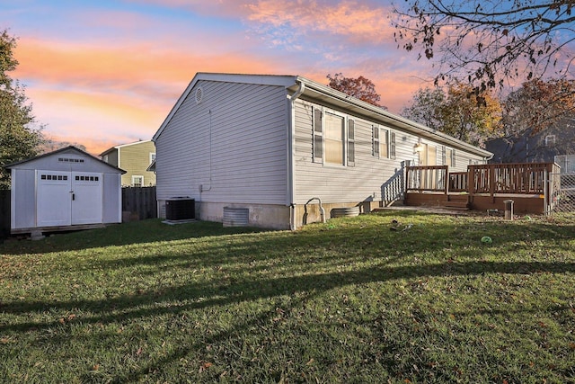 35634 N Greenleaf Ave, Ingleside, IL 60041 - back of house at dusk with a shed, a wooden deck, a lawn, an outdoor structure, and central air condition unit