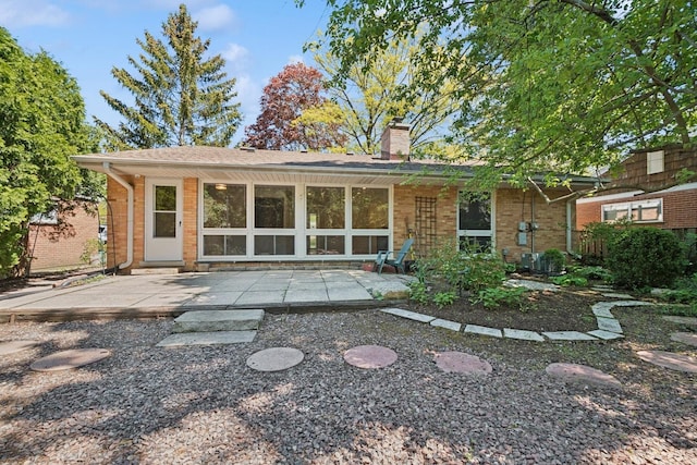 9032 Crawford Ave, Skokie, IL 60076 - back of property with a patio, a chimney, and brick siding