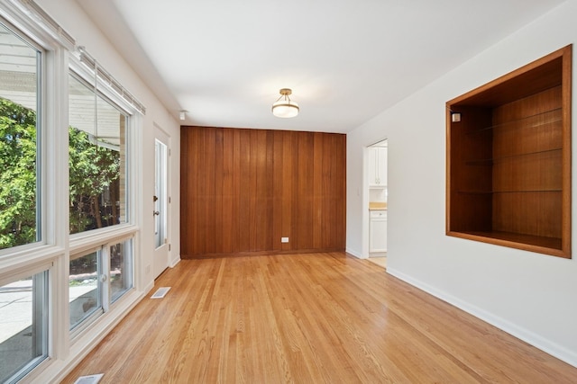 9032 Crawford Ave, Skokie, IL 60076 - spare room with light wood-style floors, healthy amount of natural light, baseboards, and wood walls
