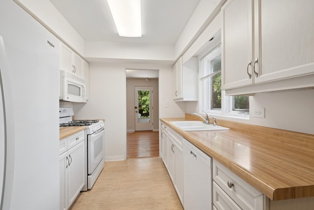 9032 Crawford Ave, Skokie, IL 60076 - kitchen featuring white appliances, light wood-style floors, a sink, white cabinetry, and baseboards