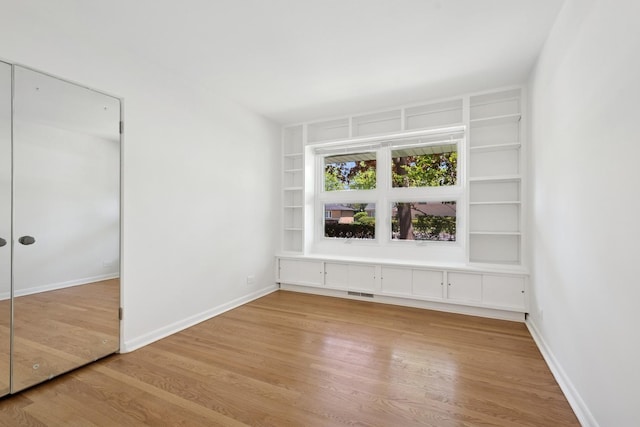 9032 Crawford Ave, Skokie, IL 60076 - spare room with wood finished floors, built in features, and baseboards