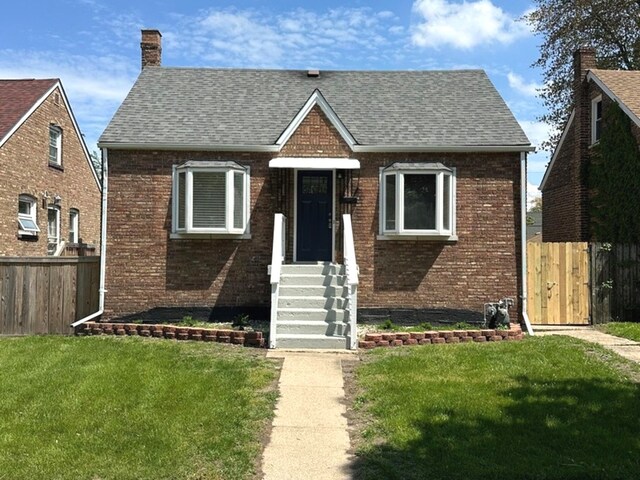 18025 Oakwood Ave, Lansing, IL 60438 - view of front of house featuring brick siding, roof with shingles, and a chimney