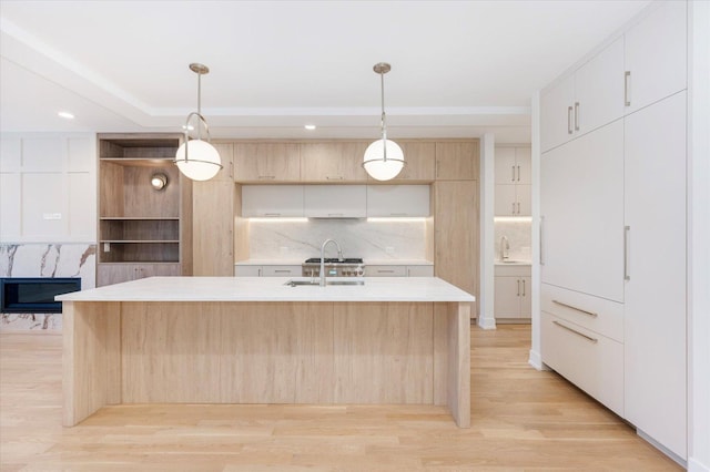 1542 W Highland Ave, Chicago, IL 60660 - kitchen featuring a sink, light countertops, light wood finished floors, modern cabinets, and decorative backsplash