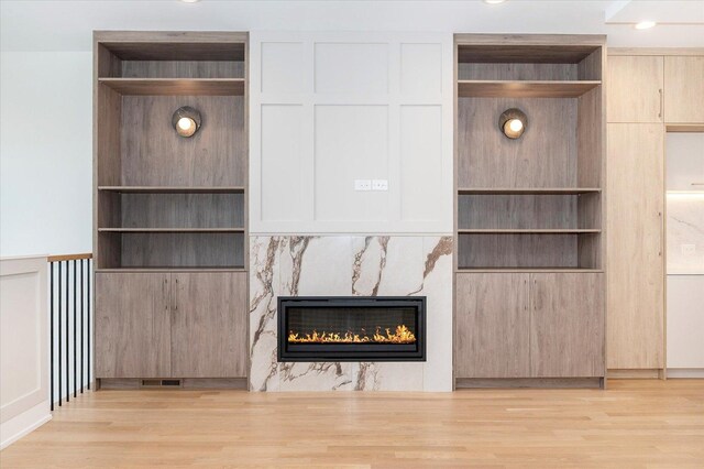 1542 W Highland Ave, Chicago, IL 60660 - unfurnished living room with wood finished floors, a fireplace, built in shelves, and a decorative wall