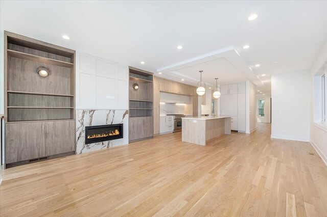 1542 W Highland Ave, Chicago, IL 60660 - unfurnished living room with a high end fireplace, light wood finished floors, recessed lighting, and baseboards