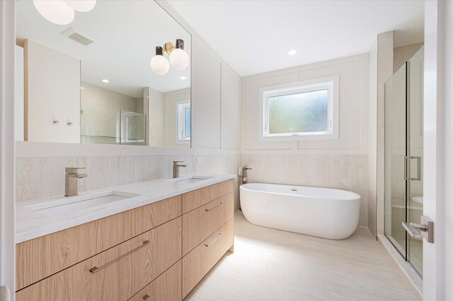 1542 W Highland Ave, Chicago, IL 60660 - bathroom featuring a stall shower, double vanity, a freestanding tub, wood finished floors, and tile walls