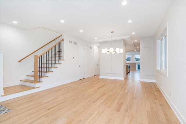 1542 W Highland Ave, Chicago, IL 60660 - unfurnished living room featuring light wood-style floors, stairway, recessed lighting, baseboards, and a chandelier