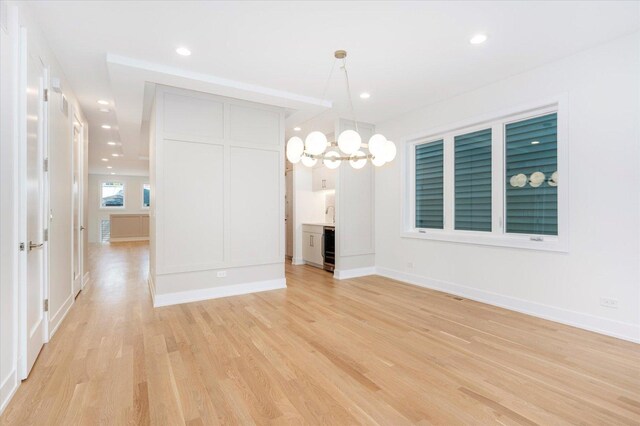 1542 W Highland Ave, Chicago, IL 60660 - unfurnished room with light wood-style floors, beverage cooler, a chandelier, baseboards, and recessed lighting