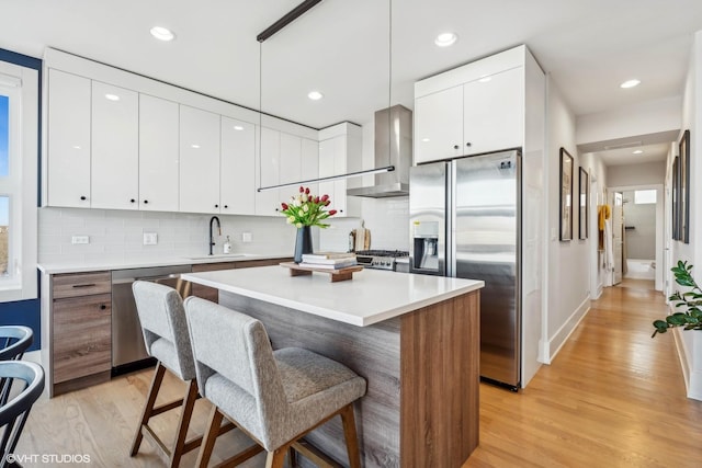 1203 E 46th St Unit 4N, Chicago, IL 60653 - kitchen featuring appliances with stainless steel finishes, wall chimney range hood, modern cabinets, a sink, and recessed lighting