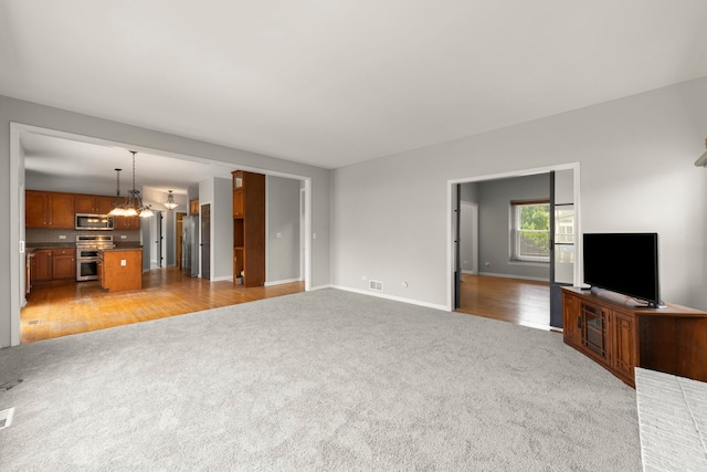 24006 Skyler Ln, Plainfield, IL 60586 - unfurnished living room featuring light carpet and a chandelier