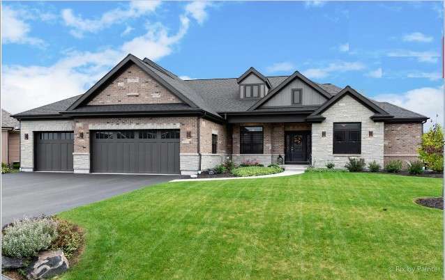 9915 Henning Dr, Huntley, IL 60142 - view of front of house with a front lawn, a garage, asphalt driveway, and brick siding