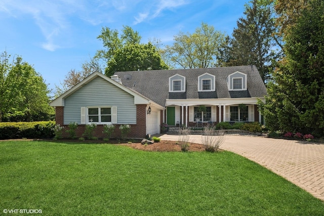 cape cod-style house featuring brick siding, driveway, a garage, a front lawn, and covered porch