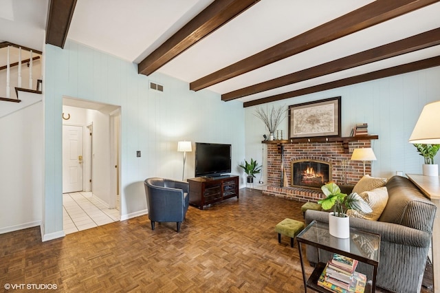 living room featuring beamed ceiling, stairs, a fireplace, and baseboards