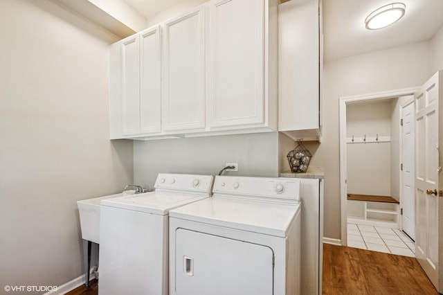 laundry room with cabinet space, washer and dryer, wood finished floors, and baseboards