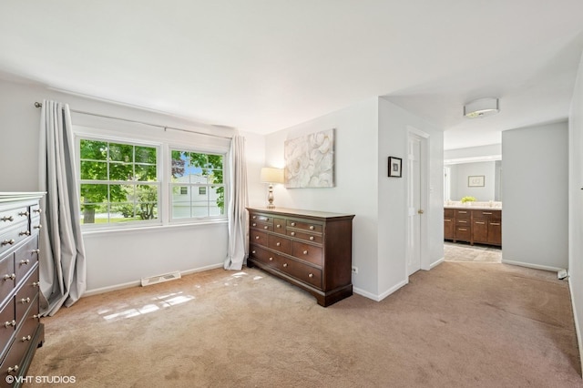 bedroom featuring light colored carpet and baseboards