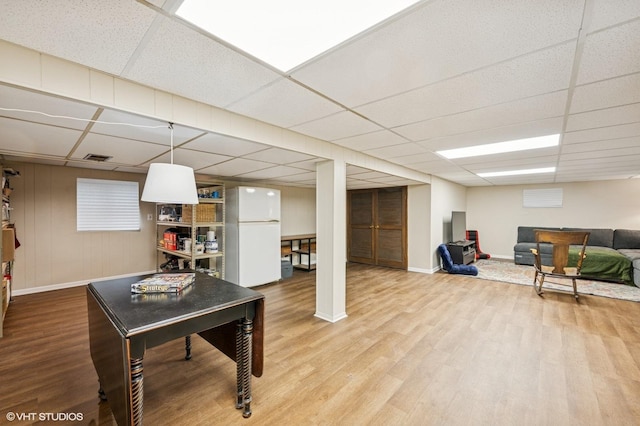 living area featuring wood finished floors, baseboards, and a drop ceiling