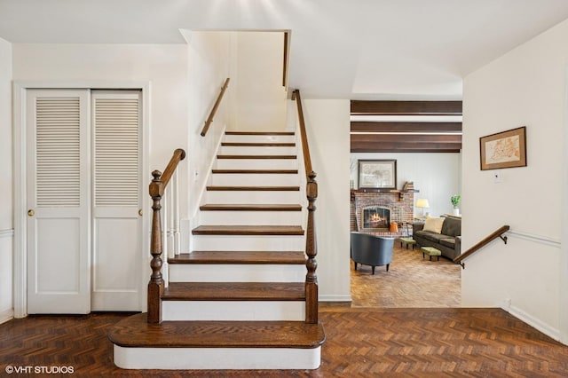 staircase with baseboards and a fireplace
