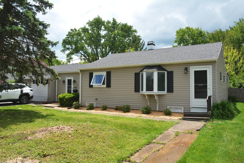 142 Pine Tree Row, Lake Zurich, IL 60047 - view of front of property featuring a front lawn, an attached garage, a chimney, and roof with shingles
