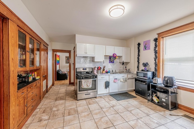 7601 W 60th Pl, Summit, IL 60501 - kitchen featuring stainless steel appliances, under cabinet range hood, tasteful backsplash, glass insert cabinets, and white cabinetry