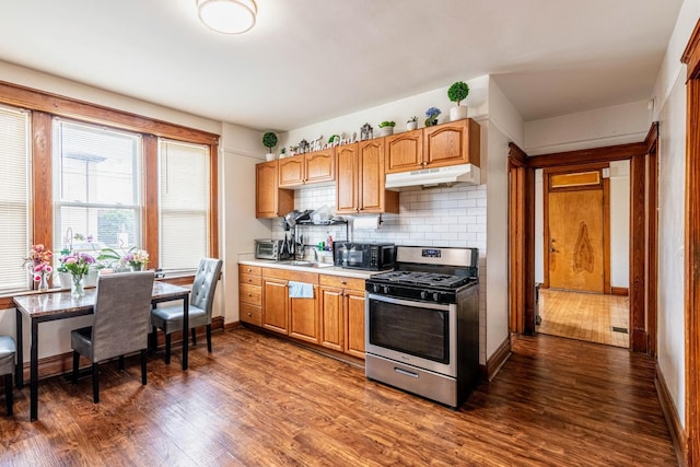 7601 W 60th Pl, Summit, IL 60501 - kitchen featuring stainless steel gas stove, under cabinet range hood, dark wood-style floors, and baseboards
