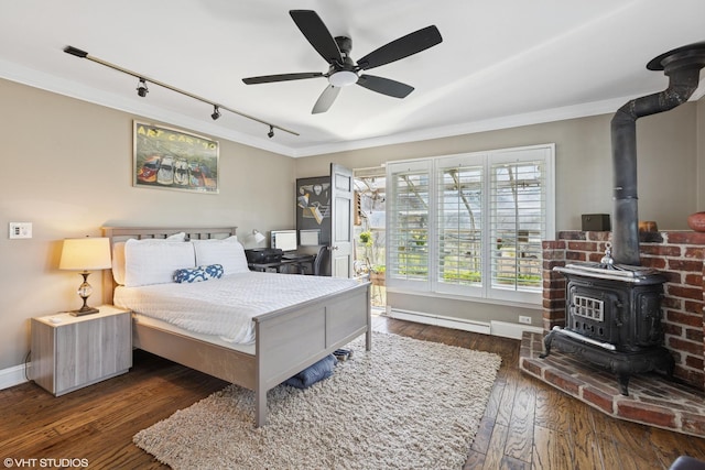 3300 Overland Pass, Northbrook, IL 60062 - bedroom with rail lighting, a wood stove, crown molding, wood-type flooring, and baseboards
