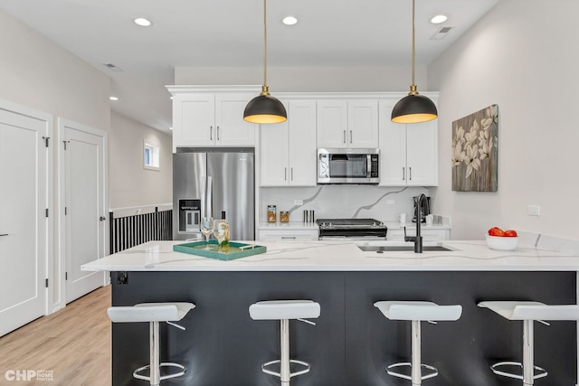 5201 S Wabash Ave, Chicago, IL 60615 - kitchen with appliances with stainless steel finishes, a sink, white cabinets, a breakfast bar, and recessed lighting