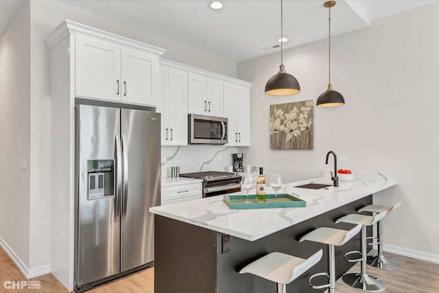 5201 S Wabash Ave, Chicago, IL 60615 - kitchen featuring stainless steel appliances, light wood finished floors, a kitchen bar, white cabinets, and recessed lighting