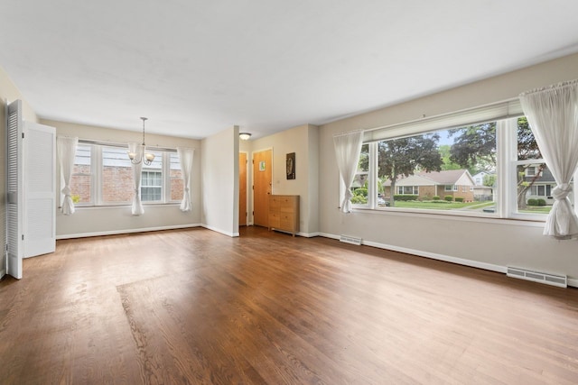 202 N Elmhurst Ave, Mount Prospect, IL 60056 - unfurnished living room with a chandelier, wood finished floors, plenty of natural light, and baseboards
