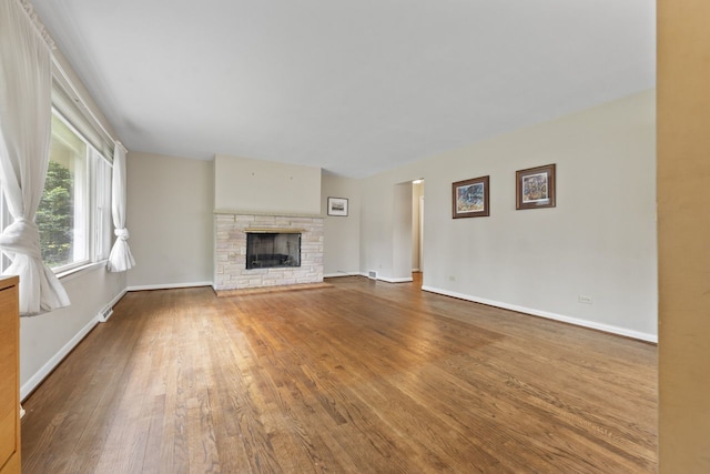 202 N Elmhurst Ave, Mount Prospect, IL 60056 - unfurnished living room featuring wood finished floors, a stone fireplace, and baseboards